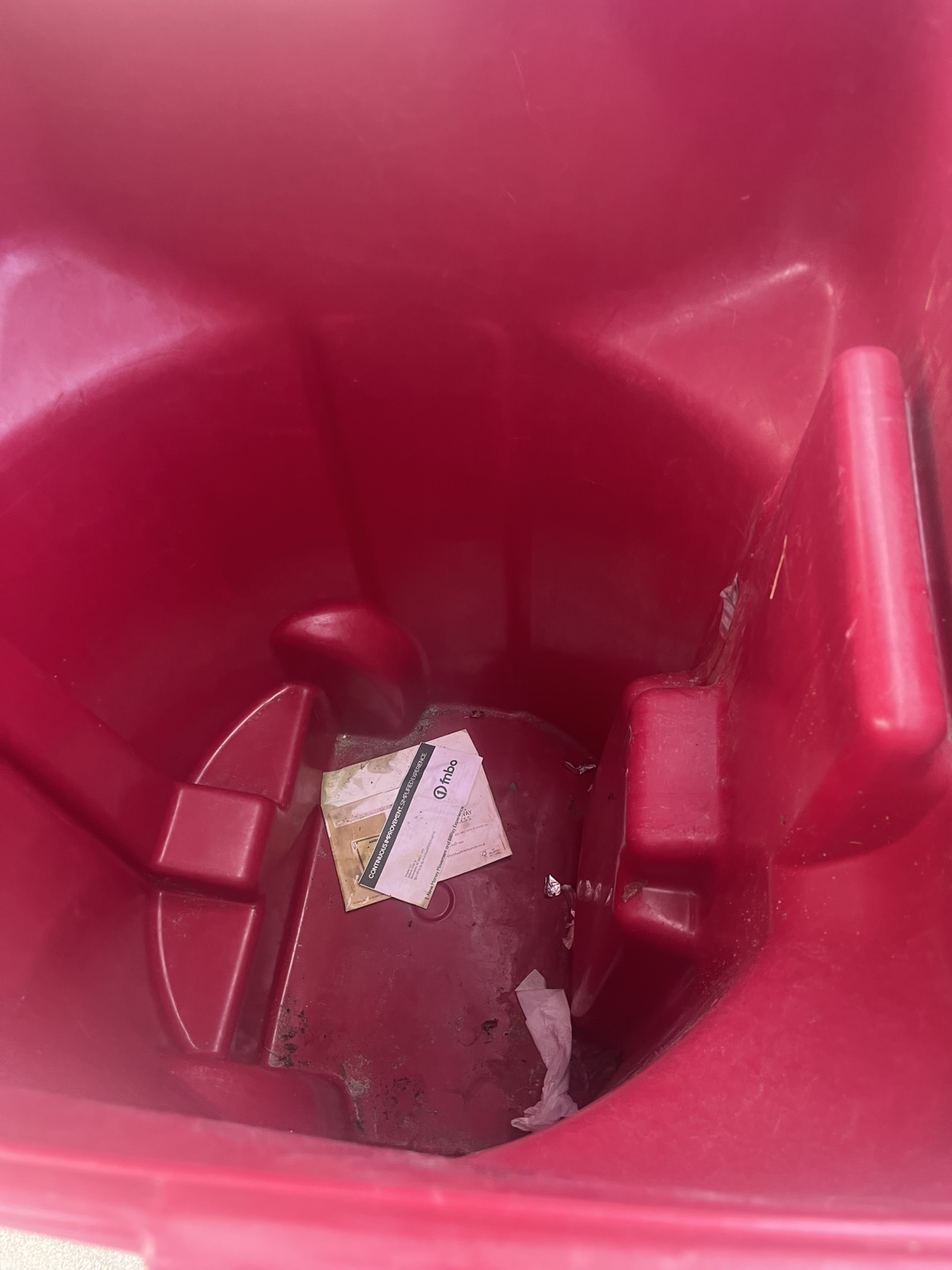 Dirty red trash bin before cleaning